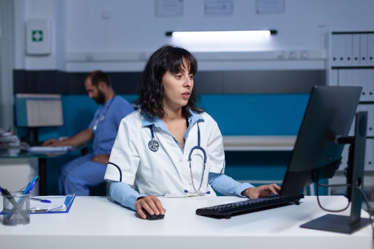 Medical office assistant working at a computer in a healthcare setting