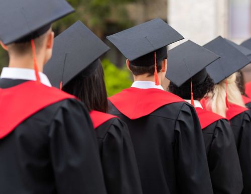 a group of students wearing graduation gowns facing forward