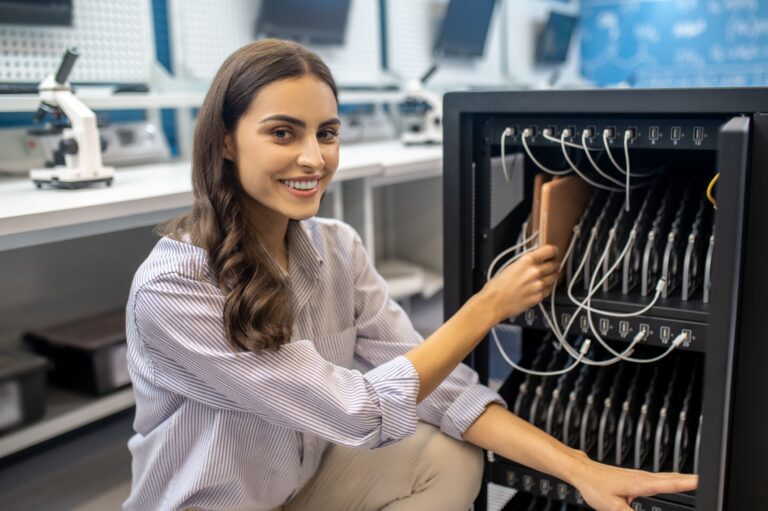 Network administrator in front of a server rack showcasing technical expertise