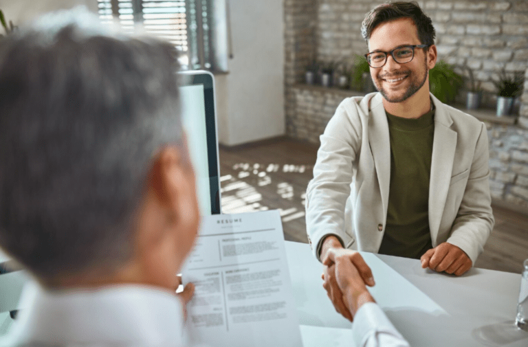 Man in a suit shaking hands during a Web Design and Development Diploma interview