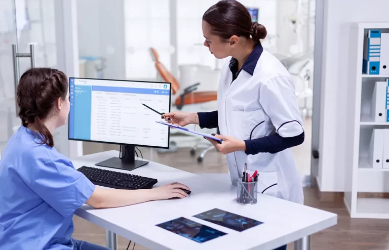 ABM College dental administration diploma graduate checking patient details in clinic