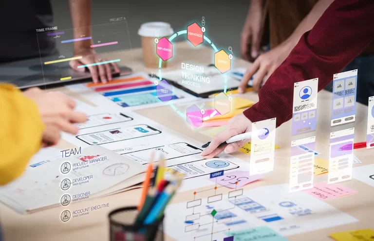 Group collaborating at a table with design materials for a UI/UX project