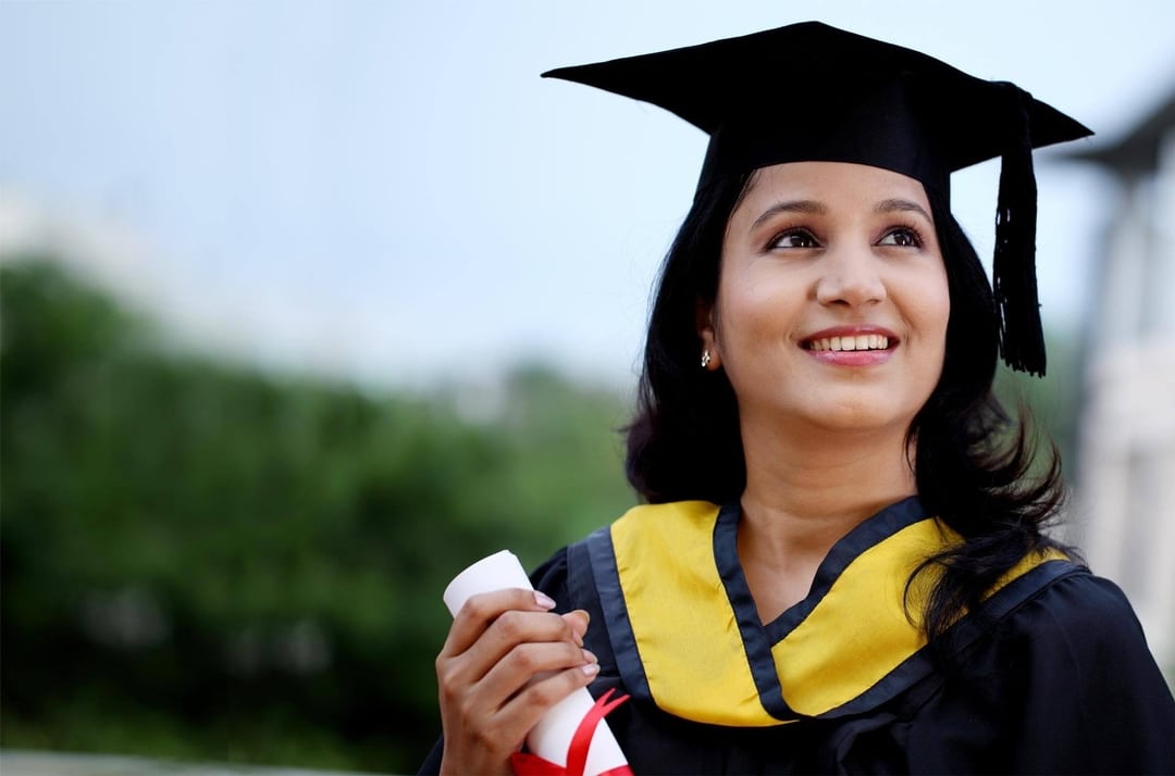 a woman in a graduation gown holding a diploma