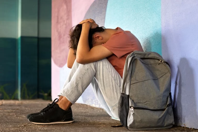 a man sitting on the ground with his head in his hands