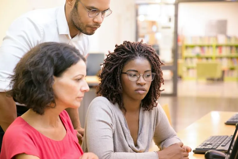 a group of people looking at a computer screen