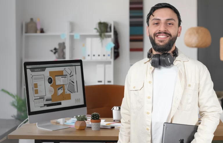 a man wearing headset and holding a laptop posing for a picture