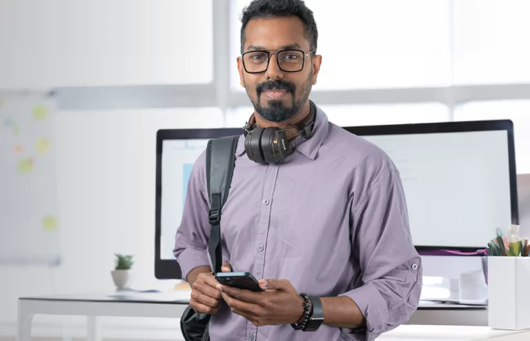 a man smiling while wearing headset and bag and posing for a picture