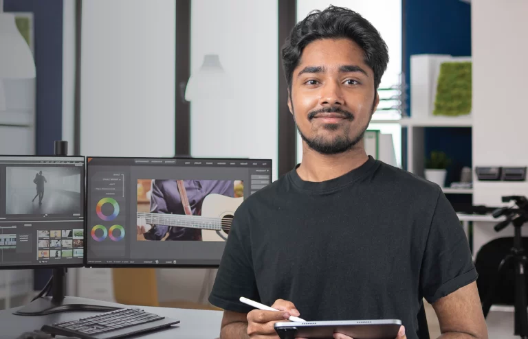 a man smiling while holding a tablet and posing for a picture